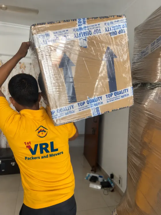 Packer lifting a labelled carton overhead onto a stack