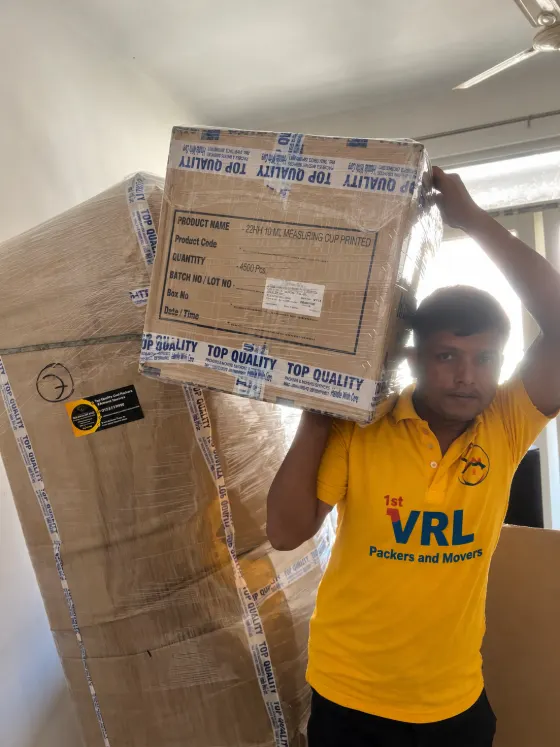 Packer carrying a carton on his shoulder to the vehicle